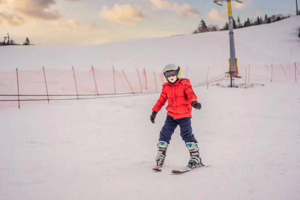 孩子们在山上滑雪。带着安全帽、护目镜和电线杆的活泼幼儿。滑雪比赛的幼儿。家庭冬季运动。高山学校的孩子滑雪课。小滑雪者在雪中赛跑 — 图库照片