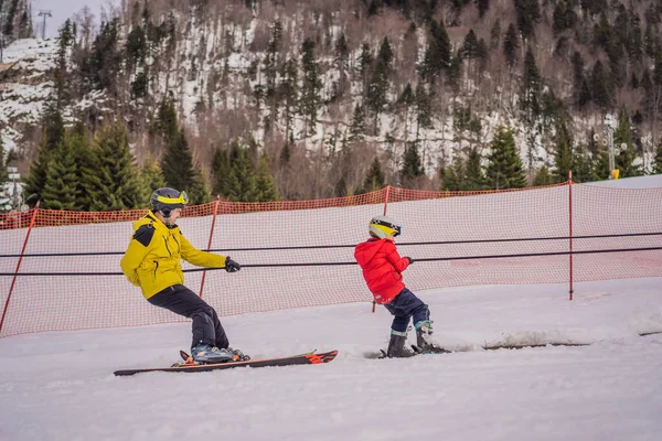 Instructeur enseigne garçon skieur à utiliser sur téléski — Photo