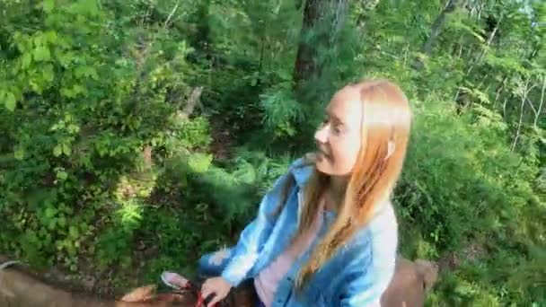 Kadın ormanda ata biniyor. Bir selfie videosu çekiyor. — Stok video