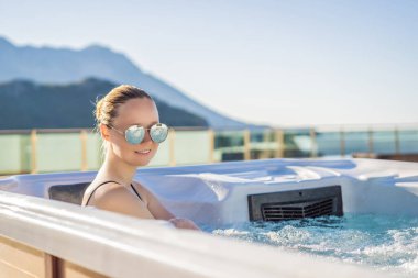 Genç kaygısız mutlu kadının portresi jakuzide rahatlayarak yeşil büyük dağların arka planında mutlu bir tatil hayatı yaşıyor.