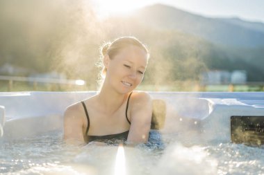 Genç kaygısız mutlu kadının portresi jakuzide rahatlayarak yeşil büyük dağların arka planında mutlu bir tatil hayatı yaşıyor.