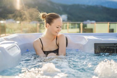 Genç kaygısız mutlu kadının portresi jakuzide rahatlayarak yeşil büyük dağların arka planında mutlu bir tatil hayatı yaşıyor.