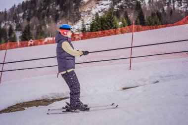 Kadın kayakçı yeni başlayanlar için kayak asansörüyle dağa tırmanır.