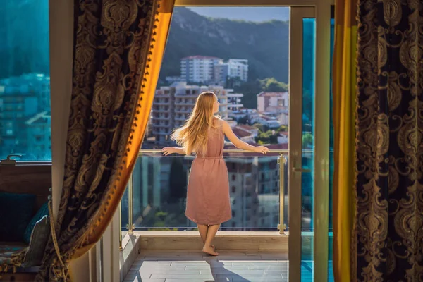 Женщина на балконе на фоне гор и города, Черногория. Жизнь терраса довольно счастье летний дом. Вдохновляющий город романтический отель — стоковое фото
