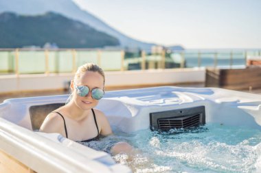 Genç kaygısız mutlu kadının portresi jakuzide rahatlayarak yeşil büyük dağların arka planında mutlu bir tatil hayatı yaşıyor.