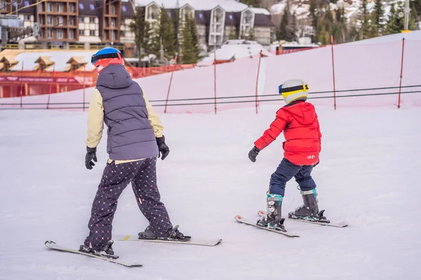 妈妈和小男孩山滑雪站在高峰滑雪与高山上背景 — 图库照片