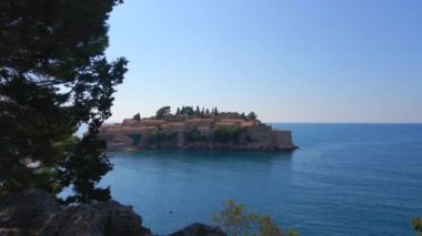 Hava görüntüsü. Sveti Stefan adasının yavaş çekim videosu. Budva şehrinin yakınlarında ünlü bir turistik mekan. Karadağ 'a Seyahat