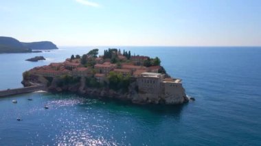 Hava görüntüsü. Sveti Stefan adasının yavaş çekim videosu. Budva şehrinin yakınlarında ünlü bir turistik mekan. Karadağ 'a Seyahat