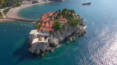 Hava görüntüsü. Sveti Stefan adasının yavaş çekim videosu. Budva şehrinin yakınlarında ünlü bir turistik mekan. Karadağ 'a Seyahat