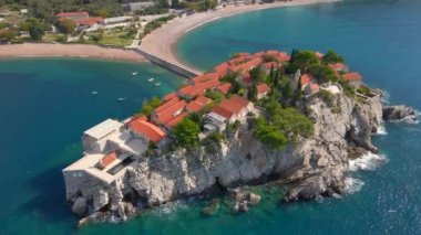 Hava görüntüsü. Sveti Stefan adasının yavaş çekim videosu. Budva şehrinin yakınlarında ünlü bir turistik mekan. Karadağ 'a Seyahat
