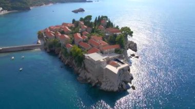 Hava görüntüsü. Sveti Stefan adasının yavaş çekim videosu. Budva şehrinin yakınlarında ünlü bir turistik mekan. Karadağ 'a Seyahat