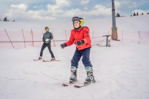 Boy learning to ski, training and listening to his ski instructor on the slope in winter — Stock Photo, Image