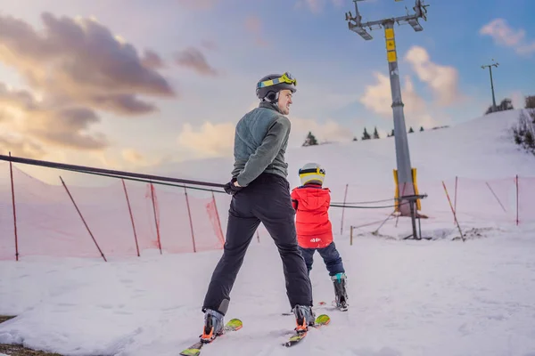 Instruktor uczy chłopca jeździć na nartach na wyciągu — Zdjęcie stockowe