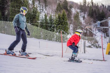 Çocuk kışın yamaçta kayak yapmayı, antrenman yapmayı ve kayak hocasını dinlemeyi öğreniyor.