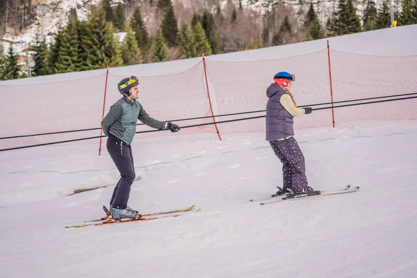 Женщина учится кататься на лыжах с инструктором. Зимний спорт. Лыжный урок в альпийской школе — стоковое фото