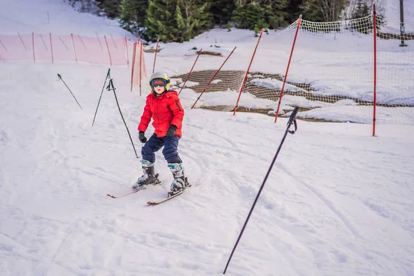 孩子们在山上滑雪。带着安全帽、护目镜和电线杆的活泼幼儿。滑雪比赛的幼儿。家庭冬季运动。高山学校的孩子滑雪课。小滑雪者在雪中赛跑 — 图库照片