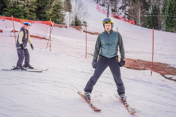 Instrutor de esqui na pista de treinamento mostrando aos alunos como esquiar — Fotografia de Stock