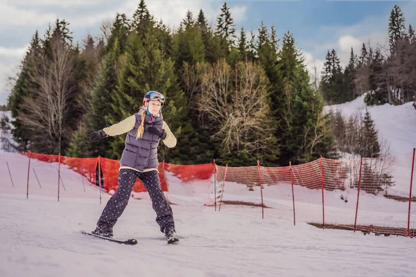 Kvinnan lär sig att åka skidor. Ung kvinna skidåkning på en snöig väg i bergen — Stockfoto