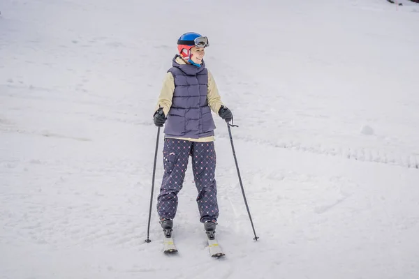 Kayak öğrenen bir kadın. Genç bir kadın dağlarda karlı bir yolda kayak yapıyor. — Stok fotoğraf
