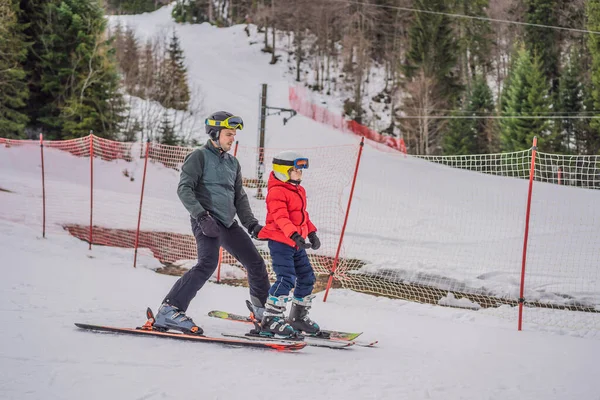 Menino aprendendo a esquiar, treinar e ouvir seu instrutor de esqui na encosta no inverno — Fotografia de Stock