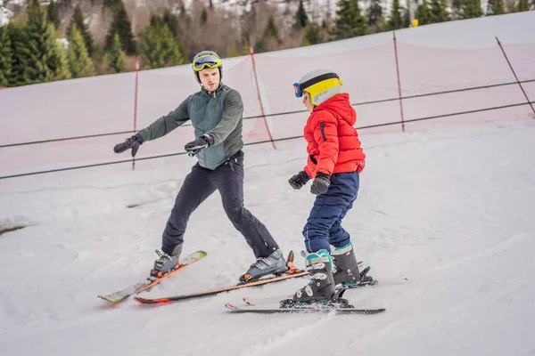 Garçon apprenant à skier, s'entraînant et écoutant son moniteur de ski sur la piste en hiver — Photo
