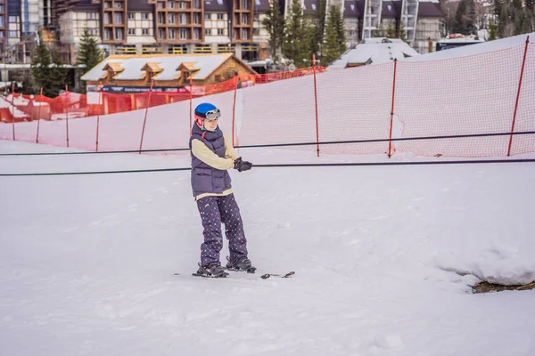 Vrouwelijke skiër beklimt een berg met een skilift voor beginners — Stockfoto