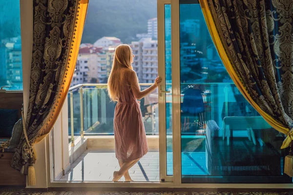 Donna sul balcone sullo sfondo delle montagne e della città, Montenegro. vita terrazza bella felicità casa estiva. Ispirazione città romantico hotel — Foto Stock