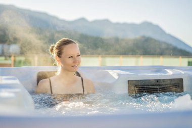 Genç kaygısız mutlu kadının portresi jakuzide rahatlayarak yeşil büyük dağların arka planında mutlu bir tatil hayatı yaşıyor.