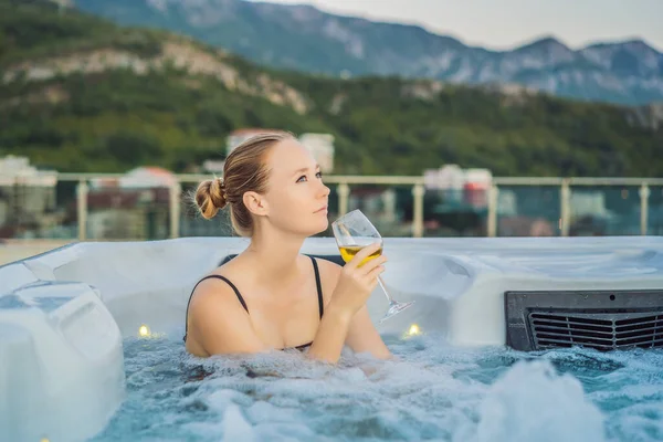 Retrato de la joven despreocupada feliz mujer sonriente relajarse en la bañera de hidromasaje durante el disfrute de la vida feliz viaje momento de vacaciones en el fondo de grandes montañas verdes — Foto de Stock
