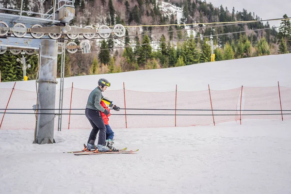 Eğitmen çocuk kayakçıya kayak kaldırmada kullanmayı öğretiyor. — Stok fotoğraf