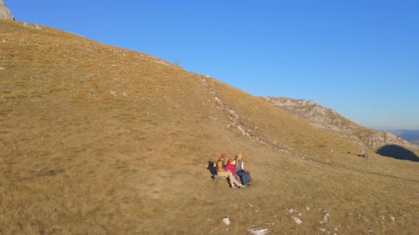 Tiro aéreo. Família de turistas visita o passo de Sedlo, Bobov Kuk nas montanhas do norte de Montenegro. Sentam-se num banco. Tiro no Outono — Vídeo de Stock