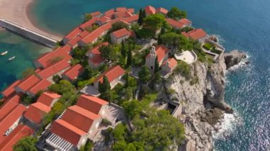 Hava görüntüsü. Sveti Stefan adasının yavaş çekim videosu. Budva şehrinin yakınlarında ünlü bir turistik mekan. Karadağ 'a Seyahat