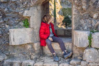 Genç turist Karadağ 'ın Kotor Körfezi manzarasının keyfini çıkarıyor. Kotor Eski Şehir Merdiveni Kotor Kalesi Yürüyüş Yolu. Hava aracı görünümü