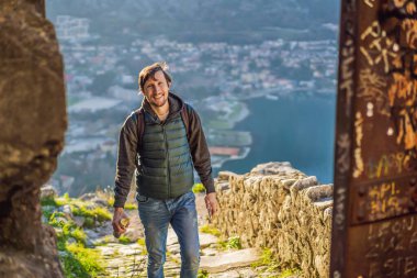 Karadağ 'ın Kotor Körfezi manzarasının tadını çıkaran bir turist. Kotor Eski Şehir Merdiveni Kotor Kalesi Yürüyüş Yolu. Hava aracı görünümü