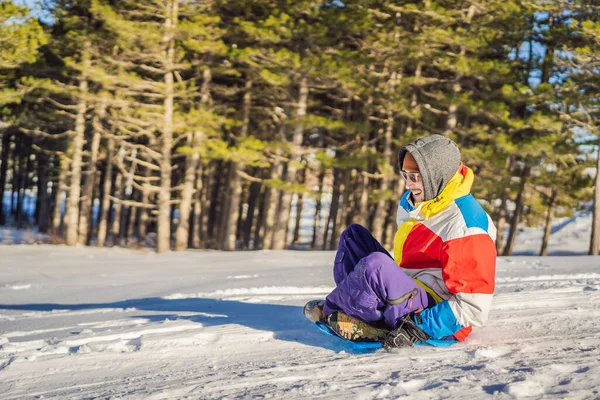 Веселый человек, скатывающийся по снежному склону на полной скорости — стоковое фото