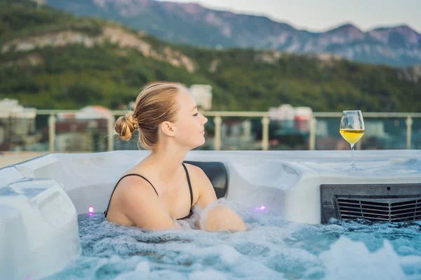 Retrato de la joven despreocupada feliz mujer sonriente relajarse en la bañera de hidromasaje durante el disfrute de la vida feliz viaje momento de vacaciones en el fondo de grandes montañas verdes —  Fotos de Stock