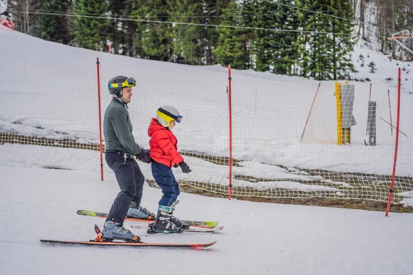 Junge lernt Skifahren, trainiert und hört seinem Skilehrer im Winter auf der Piste zu — Stockfoto