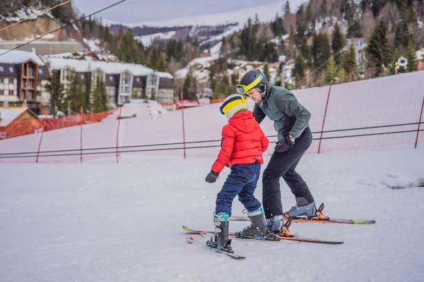 Chłopiec uczy się jeździć na nartach, trenować i słuchać instruktora narciarstwa na stoku zimą — Zdjęcie stockowe