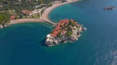 Hava görüntüsü. Sveti Stefan adasının yavaş çekim videosu. Budva şehrinin yakınlarında ünlü bir turistik mekan. Karadağ 'a Seyahat