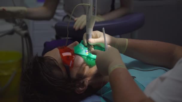女性歯科医は男を扱う。歯から神経を除去するプロセス — ストック動画