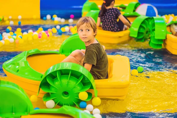 Niño feliz en el barco disfrutando jugando en el parque de atracciones — Foto de Stock