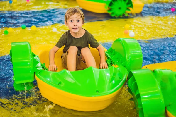 Jovem feliz no barco desfrutando de jogar no parque de diversões — Fotografia de Stock