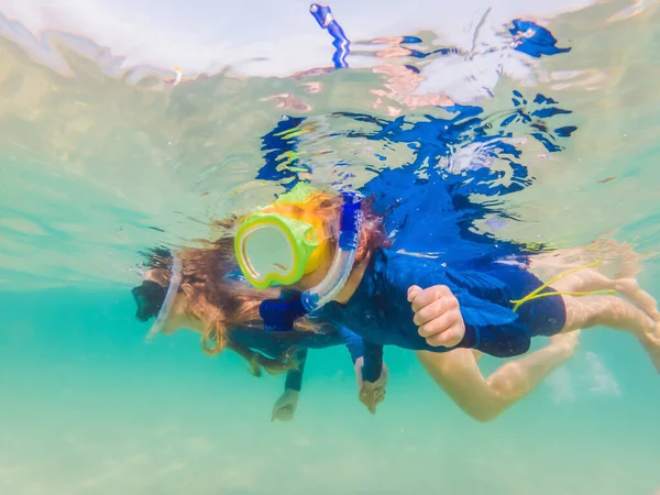 Glückliche Mutter und Sohn beim Schnorcheln im Meer. Blick auf die Fische unter Wasser — Stockfoto