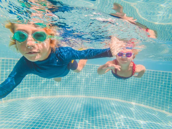 Kinder spielen in den Sommerferien unter Wasser im Schwimmbad — Stockfoto