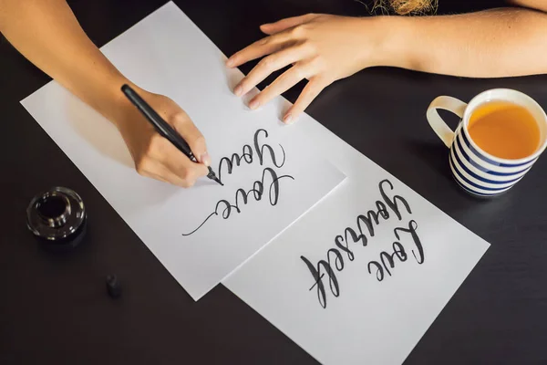 Szeresd magad. Kalligráfus fiatal nő írja mondat a fehér papíron. Inscribing díszes díszített leveleket. Kalligráfia, grafikai tervezés, betűk, kézírás, létrehozás koncepció — Stock Fotó