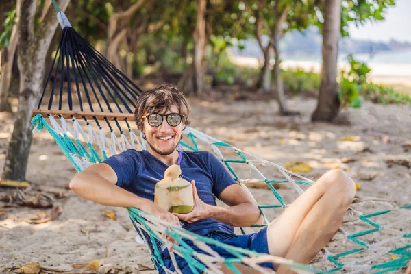 Joven en la playa en una hamaca con una bebida —  Fotos de Stock