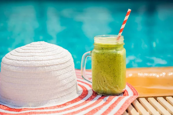 Зелені коктейлі зі шпинату та банана на фоні басейну. Здорова їжа, здорові коктейлі — стокове фото