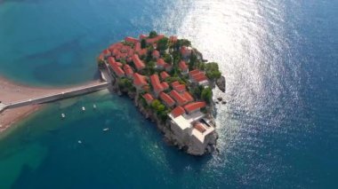 Hava görüntüsü. Sveti Stefan adasının yavaş çekim videosu. Budva şehrinin yakınlarında ünlü bir turistik mekan. Karadağ 'a Seyahat