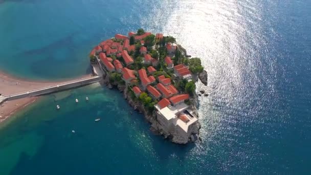 Un disparo aéreo. Vídeo en cámara lenta de la isla de Sveti Stefan. Famosa ubicación turística cerca de la ciudad de Budva. Viajes a Montenegro concepto — Vídeos de Stock