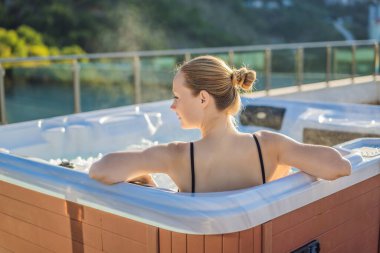 Genç kaygısız mutlu kadının portresi jakuzide rahatlayarak yeşil büyük dağların arka planında mutlu bir tatil hayatı yaşıyor.
